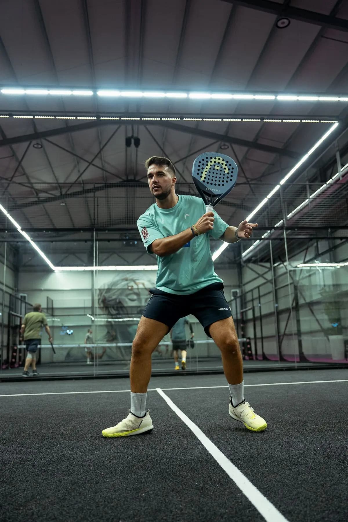 Daniel Perdomo Marrero waiting in the ready position on an indoor court, racket raised